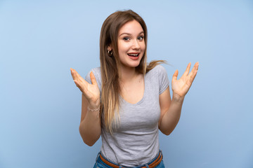 Teenager girl over isolated blue wall smiling a lot