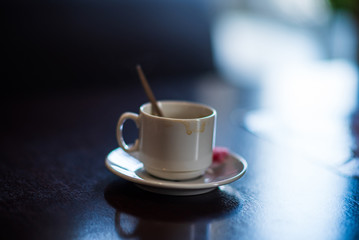 A cup of coffee drunk on a dark table in a cafe.