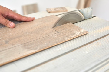 Skilled carpenter cutting a laminate wood, using a circular saw.