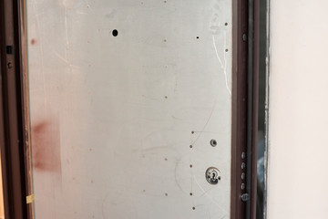 Closeup fragment of open reinforced door with a lock . Door in construction only metal part