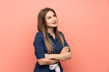 Obraz premium Teenager girl over isolated pink background looking up while smiling