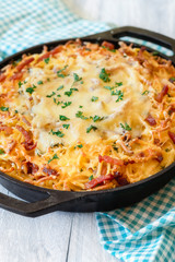 Cheese spaetzle in iron cast pan close-up. German food