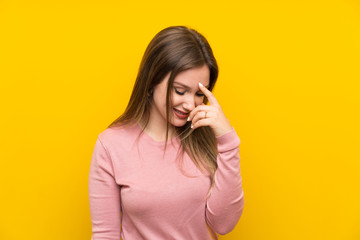 Teenager girl over isolated yellow background laughing