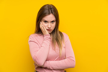 Teenager girl over isolated yellow background unhappy and frustrated