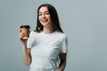 Fototapeta premium happy beautiful girl in white t-shirt with paper cup isolated on grey