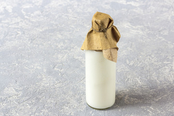 Glass bottle of yogurt on grey background.  The concept of healthy dairy