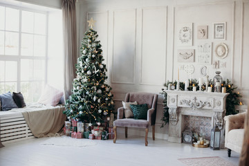 beautiful modern design of the room in delicate light colors decorated with Christmas tree and decorative elements