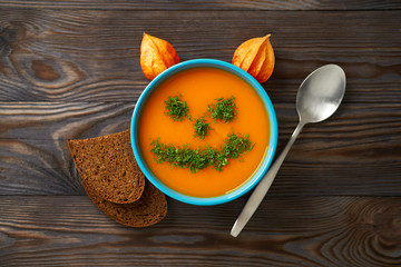 Autumn cream soup garnished with dill in the form of funny faces Halloween pumpkins. Healthy...