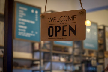 Welcome we are open. A welcome sign for cafes or shop visitors on glass door background