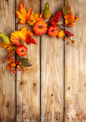 Festive autumn decor from pumpkins, berries and leaves on a rustic wooden background. Concept of Thanksgiving day or Halloween. Flat lay autumn composition with copy space.