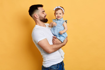 lovely beautiful sweet girl enjoying sitting on her daddy's hands. best unforgettable moment. close...