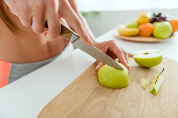 Obraz na płótnie Canvas selective focus of woman cutting fresh apple near fruits