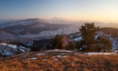 Fototapeten Sunset winter mountain landscape on the background of the town village valley © grimarr