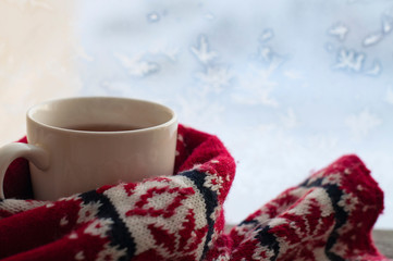 cup of tea by the snowy window, winter or christmas concept