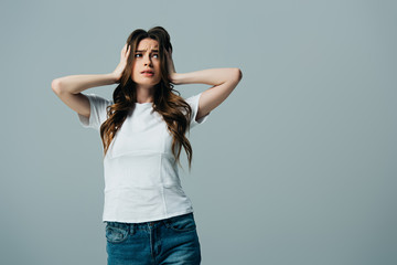 tired beautiful girl in white t-shirt touching head isolated on grey