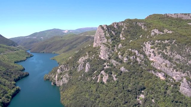 Aerial view of river in valley and country road on the side, Veria Greece, motion in front of a drone