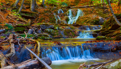 beautiful small mountain creek rushing through a canyon in a dry autumn leaves
