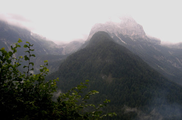 Wysokie alpejskie szczyty górskie we mgle 