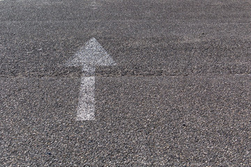 white forward way direction arrow on asphalt road