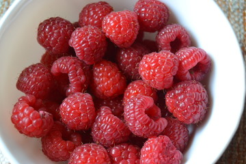 raspberries in the small white bowl. fresh organic berries.
