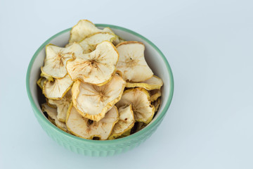 Apple chips in alight green  bowl isolated  healthy vegitarian food