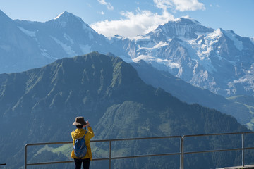 Schynige Platte, Berne - august 11, 2019: a tourist is taking photos of the swiss mountains