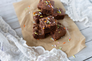 Banana brownies with multi colored sprinkles, crinkled parchment paper, lace fabric