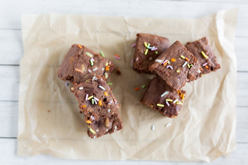 Top view of banana brownies with multi colored sprinkles, crinkled parchment paper