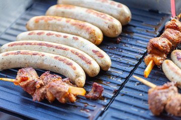 A lot of sausages lies on a grill