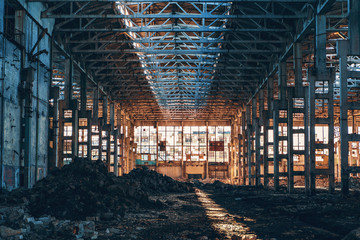 Ruined and abandoned industrial factory warehouse hangar with perspective view