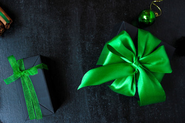 Christmas background with dry orange,white pinecone,green christmas tree balls,mandarins,red apple,ginger sticks,on a black background,flat lay,space for text,space for copy