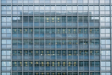 Obraz premium Abstract urban or technology background featuring detail of modern tall office buildings in downtown Tokyo, Japan, with windows textures illustrating modern business district