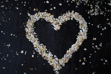 heart symbol from oatmeal on black background with oatmeal muesli bar and honey cookies word love shaped,valentine s day concept