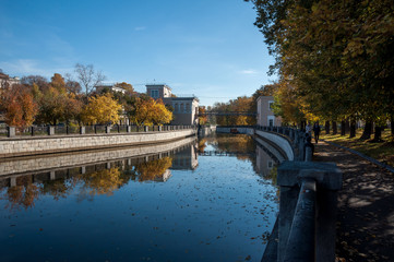 Fototapeta na wymiar Autumn city river embankment landscape. Trees are reflected in the water. Yauza River Embankment, Moscow, Russia