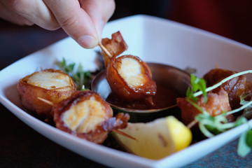 Scallops wrapped in bacon and slice of a lemon