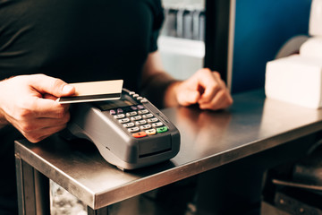 cropped view of man with credit card using payment terminal