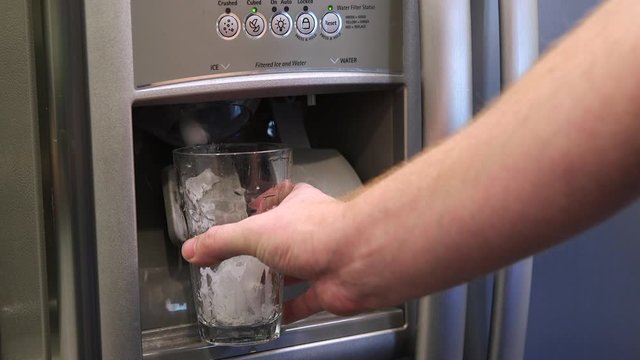 Ice pouring into glass from fridge