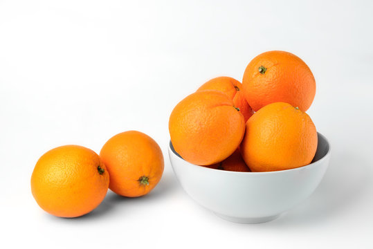 Fresh juicy oranges on white plate on white background