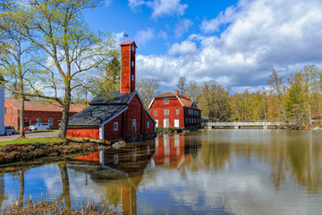 Obraz premium Old factory wooden buildings painted in traditional red ochre at Stromfors Iron Works, Finland.