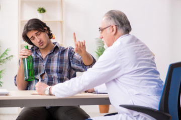 Young male alcoholic visiting old doctor