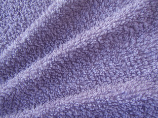 Fototapeta na wymiar Beautiful soft folds on a towel. Macro. Violet fabric background.