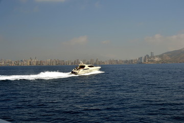 Buildings and boat, Benidorm city with seafront in Alicante Mediterranean of Spain