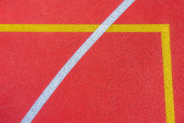 Fototapeta na wymiar Colorful sports court background. Top view to red field rubber ground with white and yellow lines outdoors