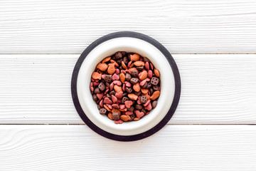Puppy dry food on white wooden background top view