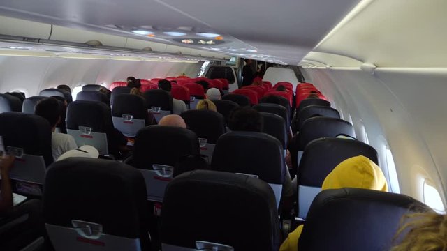 Interior passengers airplane with people. Aircraft cabin with rows of seats.
