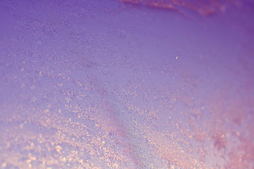 Ice patterns on winter glass of window, with the light seen through it. Light violet duotone....
