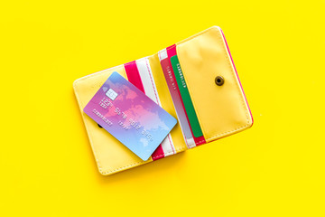 Credit cards in wallet for online payment on yellow background top view
