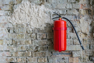Fire extinguisher on a brick wall construction building location