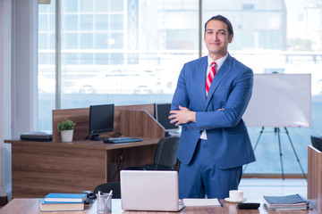 Young handsome businessman sitting in the office