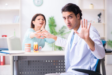 Middle-aged woman visiting male doctor stomatologist